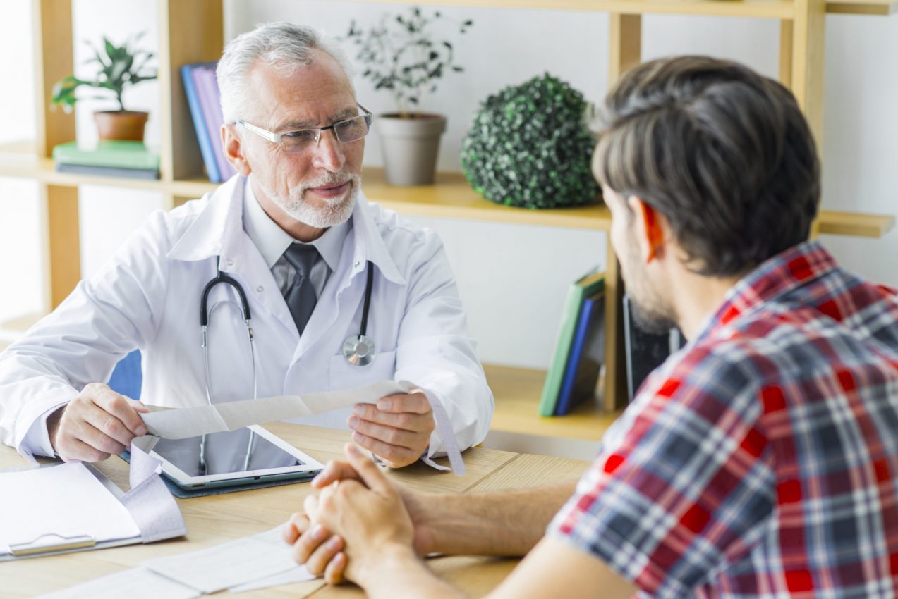 elderly-doctor-listening-young-patient